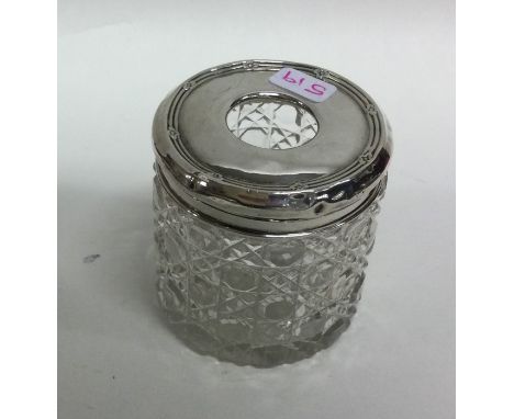 A small engine turned silver hat pin jar with glass body. Est. £10 - £20.