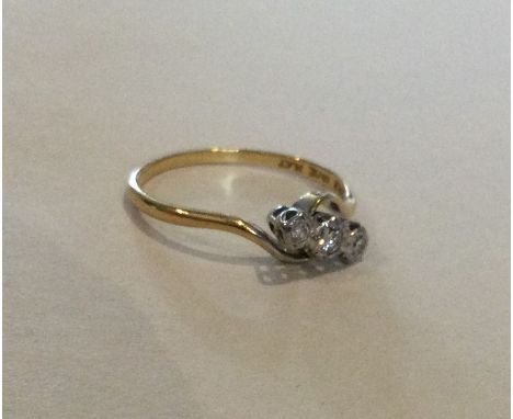 A diamond three stone crossover ring in 18 carat gold. Approx. 2 grams. Est. £30 - £50.