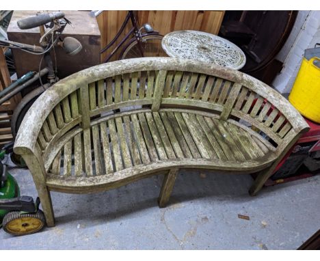 A late 20th century teak curved back garden bench with serpentine front seatLocation: 