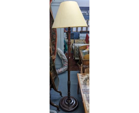 A mid 20th century mahogany standard lamp with a turned column and on three bun shaped feet Location: 