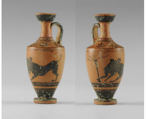 5th-3rd century BC. 
A slender ceramic lekythos with dimpled base, broad shoulder, narrow neck, cupped rim, strap handle to t