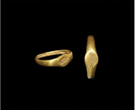 1st century AD.
A flat-section gold child's ring with expanding shoulders, discoid plaque with intaglio frond motif. 1.49 gra