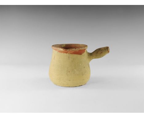 12th-14th century AD. 
An unglazed ceramic vessel with rounded body, flared rim with pouring lip, single bulb handle; red sli