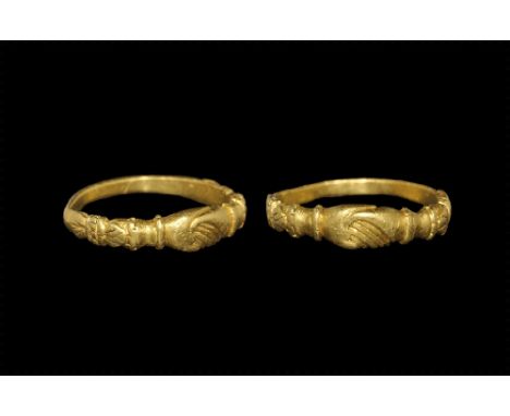 15th century AD. 
A D-section gold hoop with bow motif to each shoulder, the bezel a pair of clasped hands with gusseted cuff