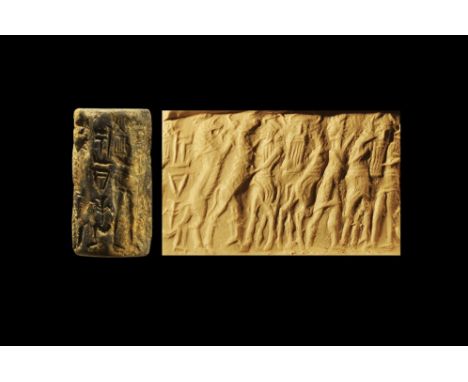 Later 3rd millennium BC.
A carved lapis lazuli cylinder seal with frieze of a standing male hero in profile between rampant a