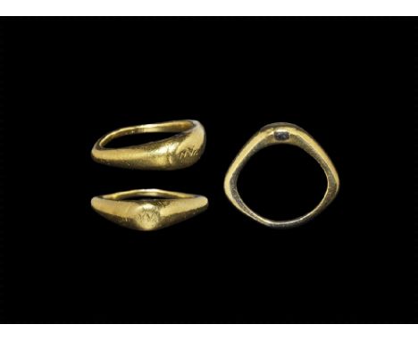 2nd century AD. A heavy square-section gold hoop with flared shoulders, discoid plaque with inset glass panels to the sides, 