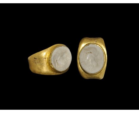 Early 3rd century AD. A flat-section gold hoop with expanding shoulders, flat plaque with cell and inset white chalcedony clo