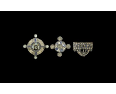 2nd century AD.
A mixed group of blue and white enamelled bronze plate brooches comprising: a disc with four satellite rounde