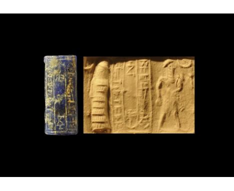 Late 2nd millennium BC. 
A carved lapis lazuli cylinder seal with a scene of a bearded king facing a figure in a flounced rob