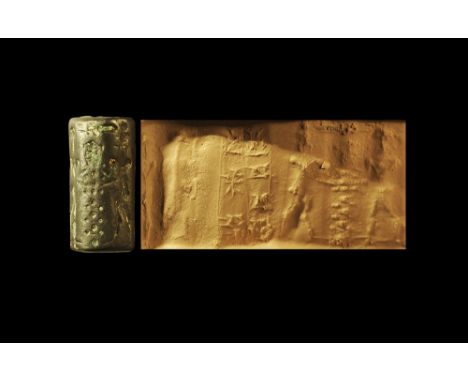 2nd millennium BC
. A haematite cylinder seal with three standing figures and two columns of cuneiform text. 7.84 grams, 21mm