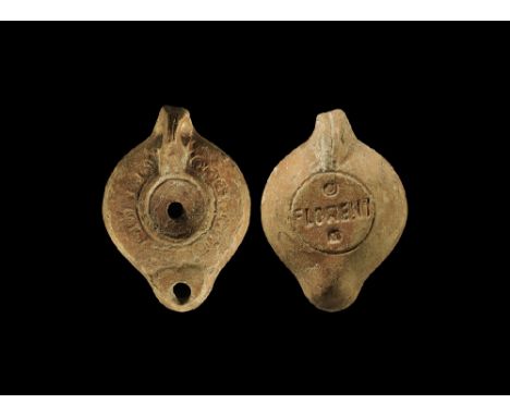 1st-2nd century AD.
A ceramic oil lamp with pierced lug handle and D-shaped nozzle; shoulder decorated with row of circles; t