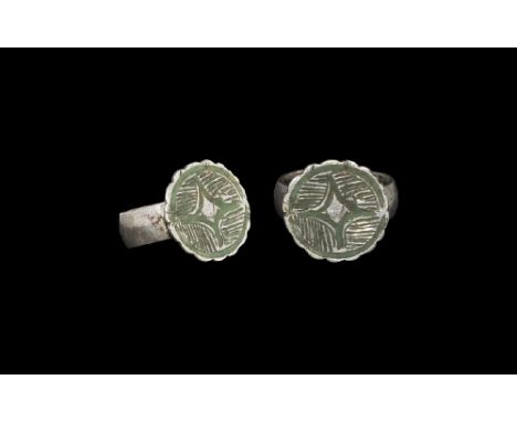 14th century AD.
A substantial D-section silver hoop with pad to the underside, discoid plaque with deckled edge, central res