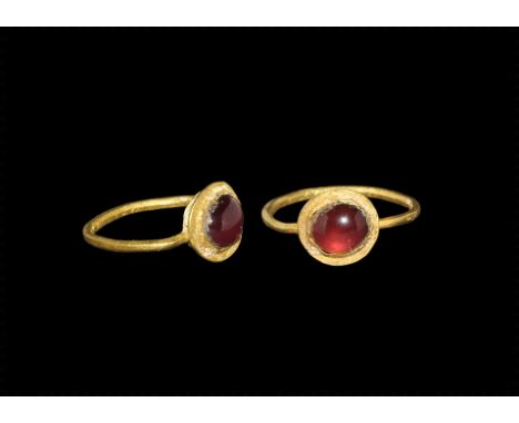 1st century AD.
A narrow round-section gold child's ring with discoid plaque, inset garnet cabochon. 0.84 grams, 15mm overall