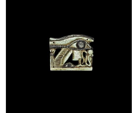 Ptolemaic Period, 332-30 BC. 
A pale blue glazed composition openwork plaque formed as the eye of Horus supported by the feat