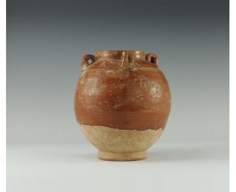 17th century AD. 
A bulbous ceramic jar with flared foot, four double-loops and two incised lines to the shoulder, low rim, p