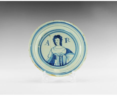 1702-1714 AD. 
A shallow dished ceramic plate with borders of blue concentric rings, the centre with a half-length portrait o