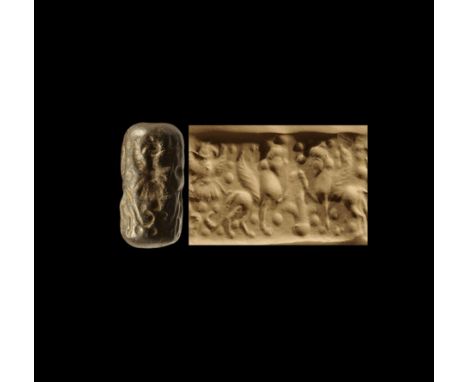 2nd millennium BC. 
A carved hardstone cylinder seal with intaglio scene of opposed winged sphinxes with one foreleg raised, 