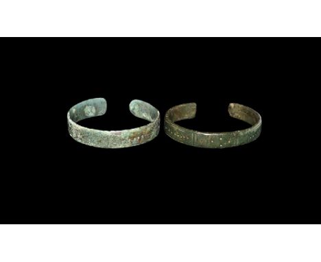 2nd-3rd century AD.
A pair of flat-section bronze penannular bracelets, each with segmented outer face, vertical pointille li