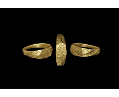 15th century AD.
A flat-section gold hoop expanding to faceted shoulders with floral and foliage detailing, hexagonal plaque 