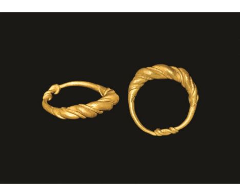 9th-11th century AD. 
A round-section tapering gold hoop with ends coiled over the shank, separate narrow wire to the bezel. 