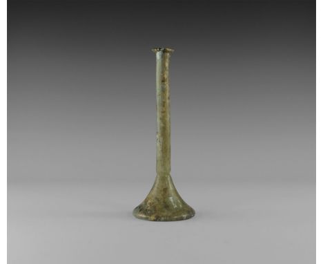 2nd-3rd century AD.
A glass vessel with broad conical base and recessed underside, slender tubular body with everted and fold