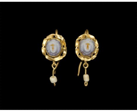 3rd century AD. A matched pair of gold earrings, each hook and discoid plaque with twisted petal detail to the outer edge, ce