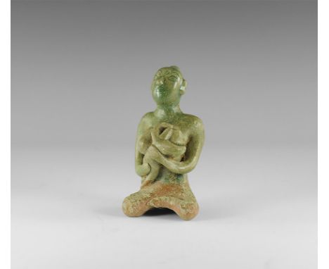 12th century AD.
A green-glazed ceramic figurine of a nude seated female suckling a baby in her arms; hollow to the underside