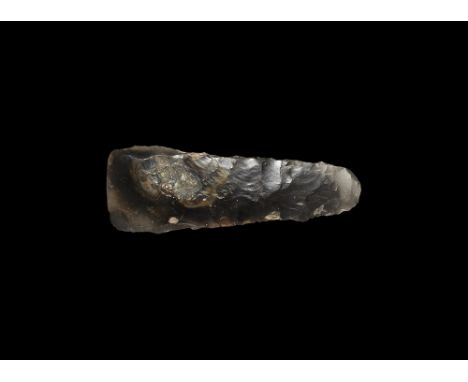 Neolithic, 3rd-2nd millennium BC. 
A knapped axe with rounded butt and polished to a slightly convex cutting edge; in grey/br