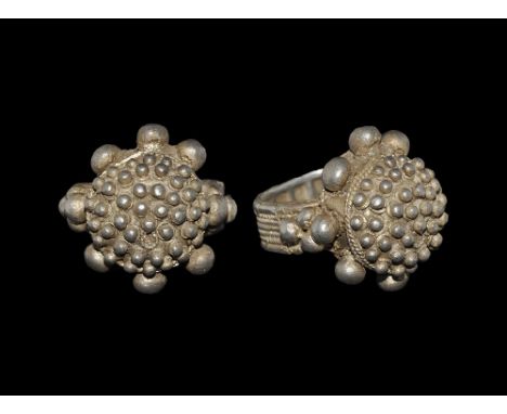 9th-11th century AD.
A large silver ring with granulation decoration; the high bezel domed and covered in a series of large a