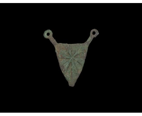 13th-14th century AD.
A heater-shaped plaque with two arms to the upper corners ending in pierced lugs; low-relief arms 'gyro