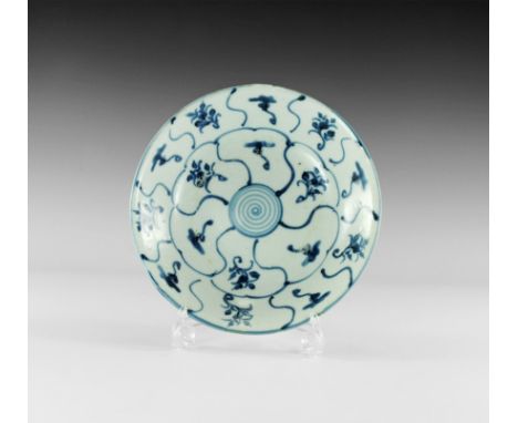 19th century AD. 
A squat blue-glazed bowl with flared rim, shallow basal ring; blue segments to both faces with floral motif