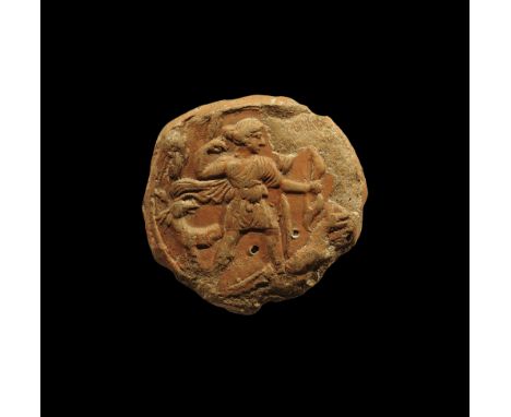 1st-3rd century AD.
A terracotta disc with raised rim, low-relief image of Diana (Artemis) standing in short robe, bow in her