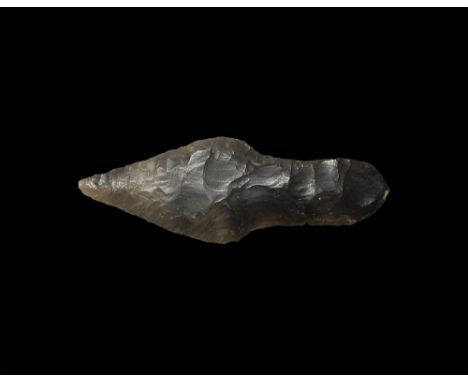 Neolithic, 2nd millennium BC.
A finely knapped triangular bifacial spearhead with pronounced tang, in a transluscent dark gre