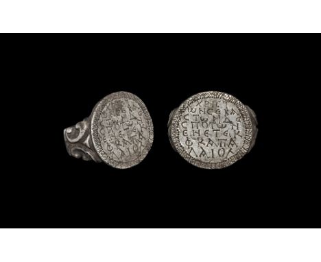 18th century AD. 
A flat-section silver hoop with volute scrolls to the shoulders, discoid plaque with hatched border, Greek 