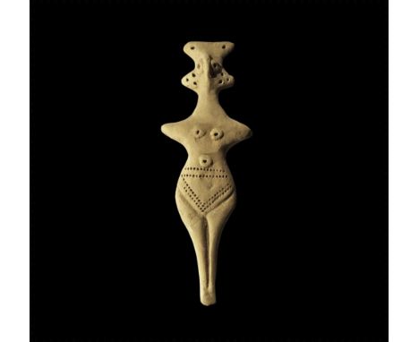 12th-8th century BC.
A ceramic idol with pinched facial features, pierced lateral flanges to the head, lozengiform lower body