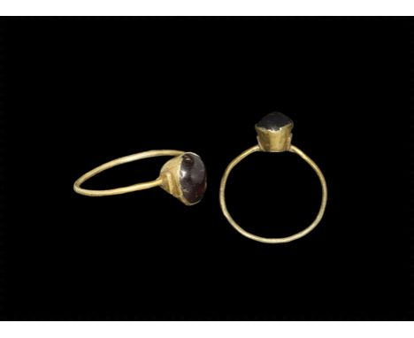 13th-14th century AD. 
A slender round-section gold hoop and tapering bezel with inset garnet cabochon. 1.08 grams, 22mm over