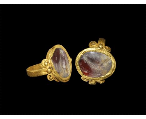 3rd century AD. A flat-section gold hoop divided at each shoulder into opposed scrolls with applied granules, discoid bezel w