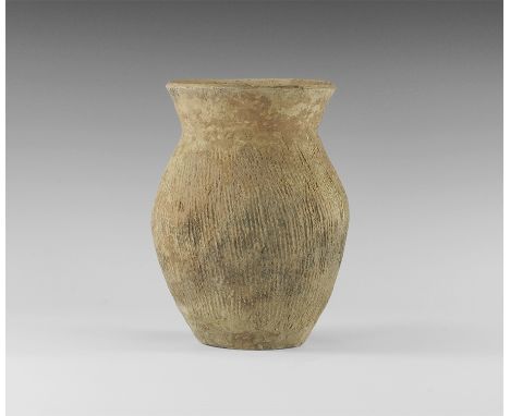 Neolithic, 3rd millennium BC. 
A biconvex ceramic jar with flared rim, ridged leather texture to the body and shoulder. 920 g