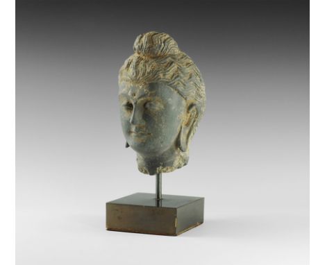 2nd-4th century AD. 
A carved schist head of Buddha with neatly dressed hair; mounted on a custom-made stand. 5.2 kg, 30cm in