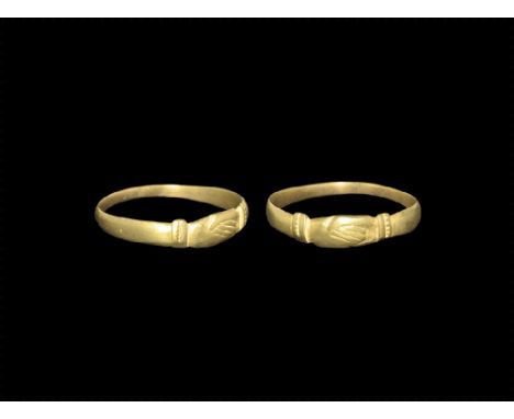 14th-15th century AD. 
A flat-section gold hoop with expanding shoulders, bezel formed as a pair of clasped hands (mane in fe