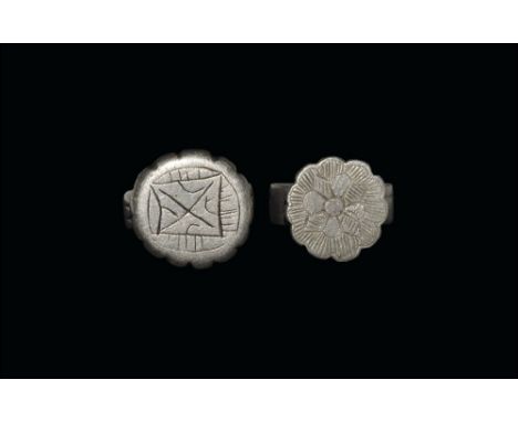 13th-15th century AD. 
A mixed pair of silver finger rings, comprising: a flat-section hoop with rosette bezel, hatched petal