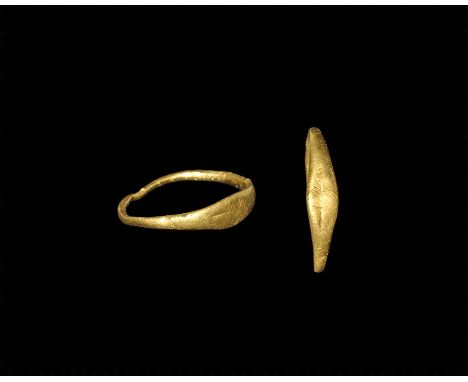 1st century AD.
A round-section gold hoop with flattened shoulders and scaphoid plaque, incised frond motif. 1.62 grams, 20mm