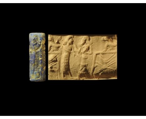Late 3rd-early 2nd millennium BC. 
A carved lapis lazuli cylinder seal with frieze of two standing figures in tiered garments