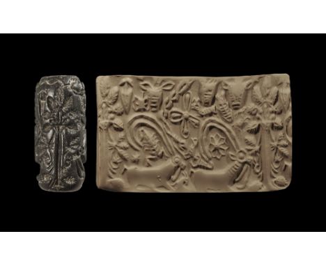 3000-2334 BC.
A carved steatite cylinder seal with image of a tree with radiating fronds, two ibexes beneath, bull-heads, fis