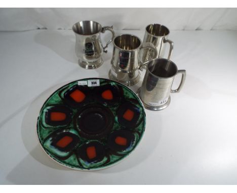 A Poole Pottery Delphis plate by Patricia Wells, approximately 17 cm (d) and four English pewter tankards. Estimate £20 - £40
