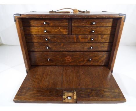 An oak cabinet with four over three drawers containing a quantity of engineering tools, approximate height 38 cm x 43 cm x 21