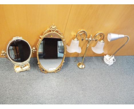 A good quality oval wall mirror with ornate frame, a brass table mirror, adjustable table lamp and a further two shade brass 