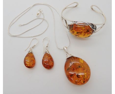 A collection of silver and amber jewellery to include a bangle, pendant and earrings Condition Report: No condition report av