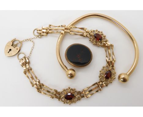 A 9ct gold garnet set gate bracelet length 19.2cm, a 9ct gold bangle and a partial fob seal, combined weight 17.3gms Conditio