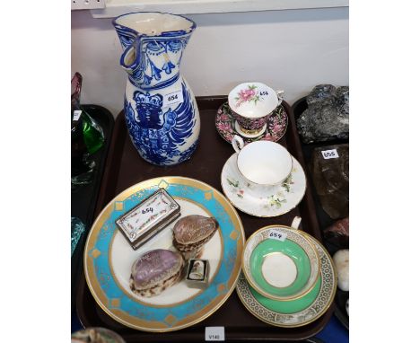 A pottery jug with blue painted eagle coat of arms, porcelain stamp box, two carved cowrie shells, cups and saucers etc Condi